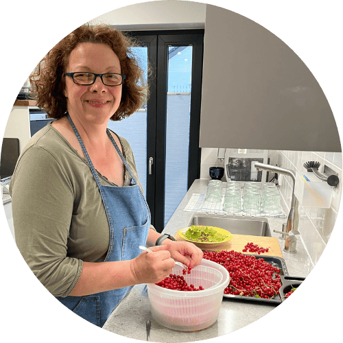 Julie in the kitchen preparing to can red currants