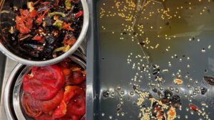 Bowl of charred red pepper skins and seeds next to bowl of skinned red peppers ready for adding to soup.